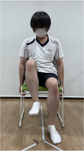 椅子に座ってもも上げ運動をする様子